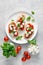 Caprese toasts with mini mozzarella cheese, cherry tomato and basil, top view