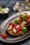 Caprese toasts with mozzarella, cherry tomatoes and fresh garden basil. Traditional italian appetizer or snack, antipasto.