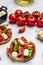 Caprese toasts with mozzarella, cherry tomatoes and fresh garden basil. Traditional italian appetizer or snack, antipasto.