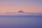 The Capri Island view from the Napoli Gulf in the lightblue evenings fog in south Italy region