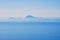 The Capri Island view from the Napoli Gulf in the lightblue mornings fog in south Italy