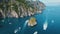 Capri Seashore with floating yachts. Dynamic waterscape with boats cruising around the iconic Faraglioni rock formations