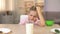 Capricious male kid looking sadly glass of milk on kitchen table, healthy meal