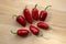 Capsicum annuum Jalapeno chilli hot peppers, group of green and red fruits on wooden table