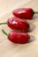 Capsicum annuum Jalapeno chilli hot peppers, group of green and red fruits on wooden table