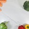 Capsicums, carrots, and broccoli on white marble background. Square.