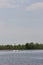 A capsized sailboat on a river with land behind it