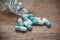 capsules and drug tablets falling from bottle on wood