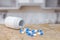 Capsules of medicine and bottle in kitchen background.