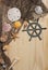 Captains Wheel With Fishing Net and Sea Shells on Wooden Background