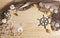 Captains Wheel With Fishing Net and Sea Shells on Wooden Background