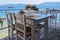 A Captivating View of an Empty Tavern Restaurant by the Picturesque Seafront, Featuring Inviting Wooden Chairs and Tables