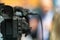 Capture the essence of media as a close-up image reveals a TV camera at a press conference