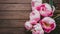 Capture Stunning pink peonies on rustic wooden background, copy space