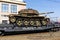 Captured tank of terrorists with artisanal reactive armor on a railway flatcar