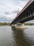 Capturing the majesty from beneath the bridge, it stretches across a vast river