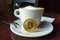 Capuccino and bitcoin gold coin on the table in cafe