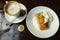 Capuccino, pancake with sour cream and bitcoin gold coin on the table in cafe