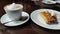 Capuccino and pancake with sour cream on the table in cafe