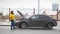 A car accident. A young woman standing by a broken car. Catching a car for help