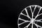 Car alloy wheel black and white beautiful modern design, on a black background, close-up element, thin spokes