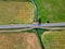 Car asphalt road with cars, river bridge crossing, meadow fields, aerial view