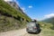 Car on the background of the Chegem gorge at the waterfall Abai-Su. Kabardino-Balkaria, June 2021.