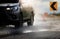 Car with big puddle of water spray from the wheels  through flood water after hard rain.