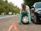 Car breakdown, tired man sitting on spare tyre