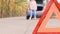 Car breakdown. Young woman walks along the road along the woods next to a broken car talking on the phone. Close-up of