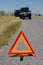 Car broken down on road with warning triangle