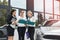 Car buy procedure. Woman dealer with tablet and buyers with folder standing near car