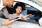 Car Buyers Choosing New Family Autombile With Seller In Store