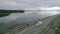 A car with a camper trailer rides along a dam across river in Canada. Landscape