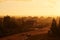 A car on a country road, in the pouring rain, in the golden colors of sunset