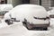 Car covered with first snow. Car buried under the snow and frozen. Bank of snow in winter.