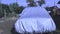 A car is covered with a protective cover.