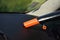 Car dashboard cleaned from dust with small orange portable vacuum cleaner