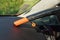 Car dashboard cleaned from dust with small orange portable vacuum cleaner