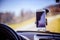 Car dashboard with smartphone used as navigation device, bright and sunny day