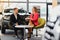 Car dealership sales person at work concept. Portrait of young sales representative wearing formal wear suit, showing vehicles at