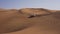 Car in the desert. A white jeep is driving across the desert.