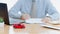 A car on desk envelope with man signing purchase documents in background. while hand complete the insurance policy, rental