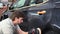 Car detailing - hands with orbital polisher in auto repair shop. Selective focus.