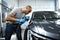 Car detailing. Male hands with orbital polisher in auto repair shop