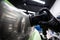 Car detailing studio worker polishes a matte front headlight of a car