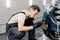 Car detailing wash. Professional car service Caucasian male worker in gray overalls and black rubber gloves, doing