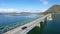 Car drive on beautiful ocean road. Footage. Black car driving on bridge blue sea, mountains and sky background. Car