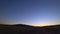 A car drives through the countryside in Arizona during sunset.