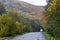 A car drives in the distance on a wet winding road after rain among the high mountains.